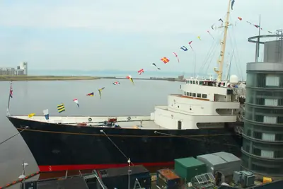 The Royal Yacht Britannia, dressed with signal flags, moored at Ocean Terminal in Leith